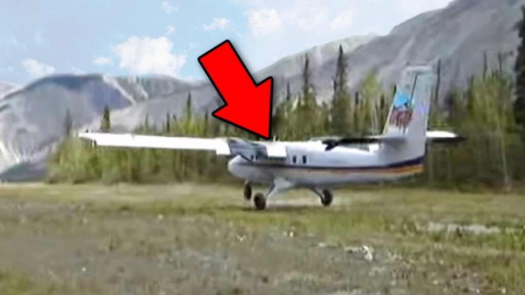 A De Havilland DHC-6 Twin Otter preparing for takeoff from a short gravel airstrip in a remote mountainous area. A large red arrow points to the aircraft's wing, highlighting a critical area. Trees and rugged mountains form the background, emphasizing the challenging takeoff conditions.