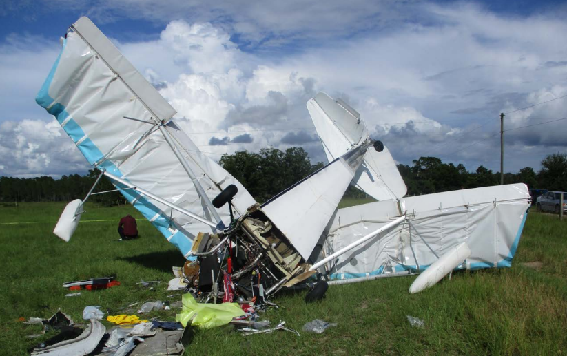 The wreckage of an experimental aircraft, registration N9143M, is seen in a field where it crashed shortly after takeoff.