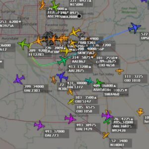 Screenshot of a live aircraft tracking map showing numerous color-coded airplanes over the Phoenix, Arizona area, with flight numbers, altitudes, and headings displayed around major airports.