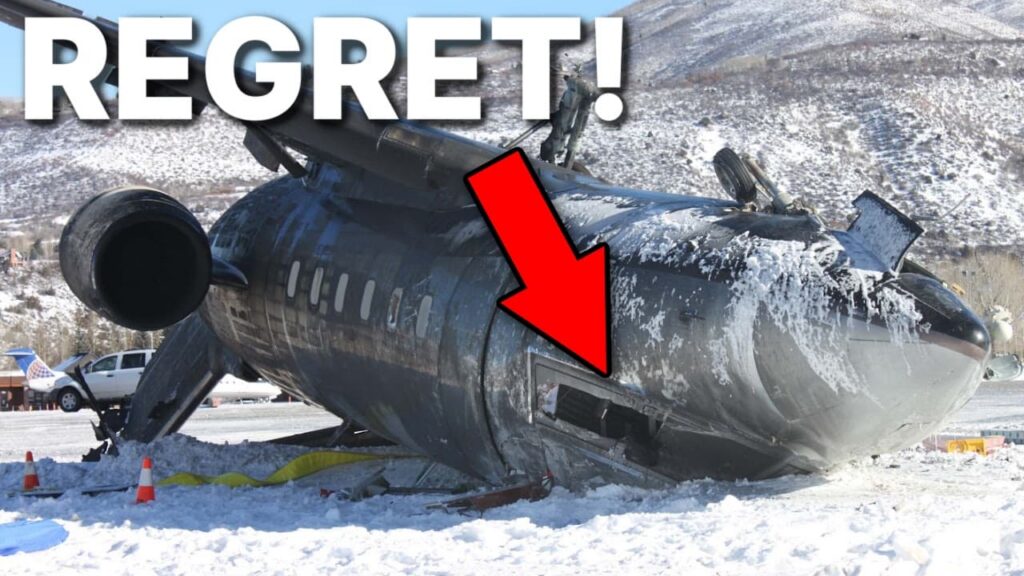 Snow-covered passenger jet lying wrecked on its side after a crash, with visible fuselage damage and debris. Large white text reads “REGRET!” across the top, and a red arrow points to a damaged section of the aircraft.